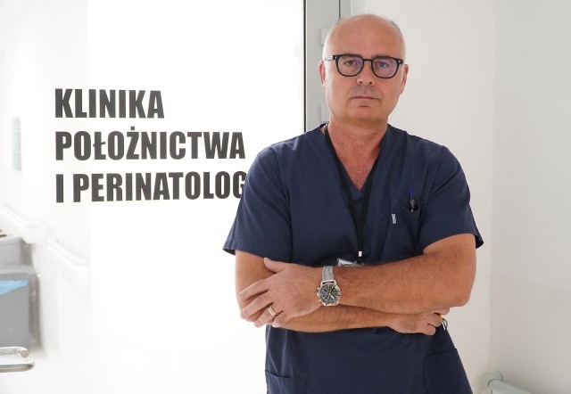 Profesor Kalinka na tle drzwi do Kliniki Położnictwa i Perinatologii